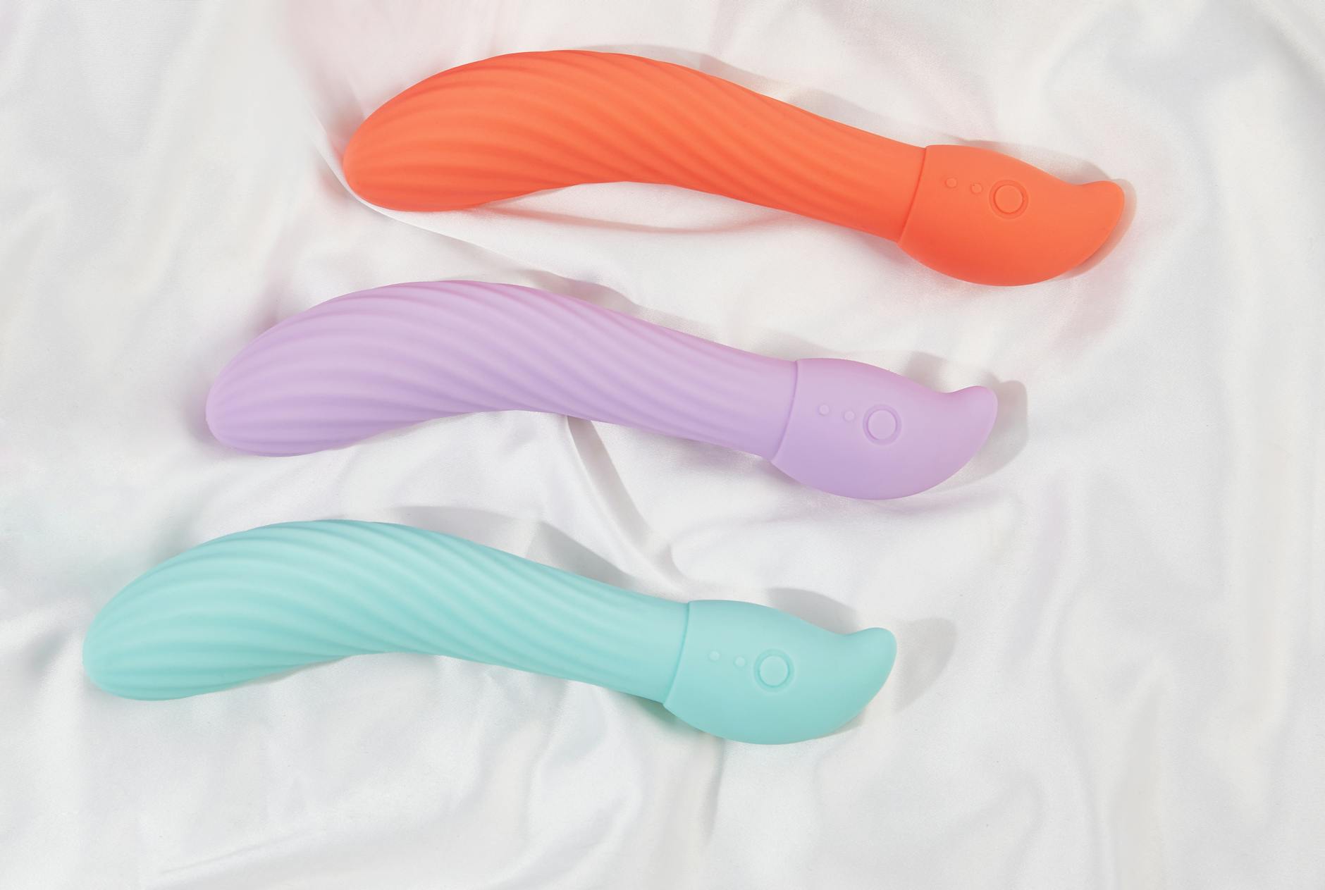 A hand holding a vibrator against a purple backdrop, representing personal agency and healing