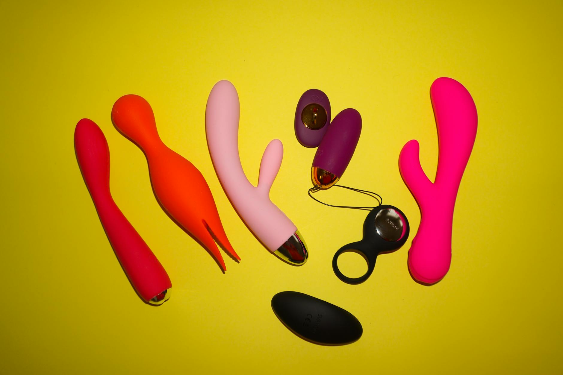 Colorful lemon vibrators and sexual wellness toys arranged on a bright yellow background